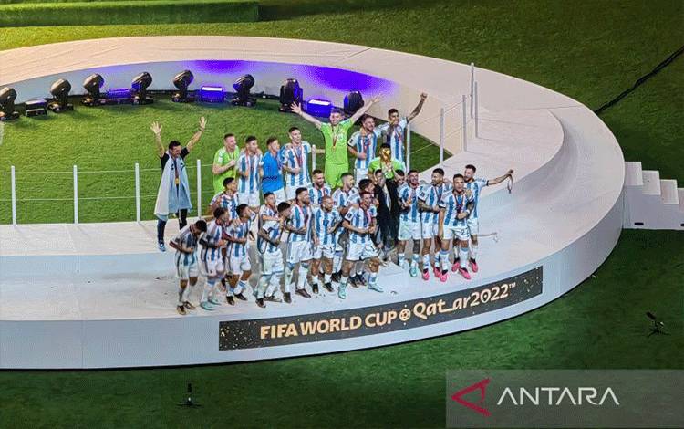 Megabintang tim nasional Argentina Lionel Messi mengangkat trofi Piala Dunia 2022 seusai memenangi adu penalti 4-2 atas Prancis dalam partai final di Stadion Lusail, Al Daayen, Qatar, Minggu (18/12/2022). (ANTARA/Gilang Galiartha)