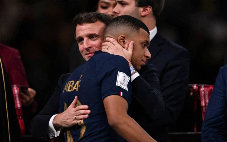Striker timnas Prancis Kylian Mbappe dihibur oleh Presiden Prancis Emmanuel Macron dalam upacara penyerahan trofi setelah Prancis kalah adu penalti melawan Argentina dalam final Piala Dunia Qatar 2022 di Stadion Lusail, Qatar, pada 18 Desember2022. (AFP/KIRILL KUDRYAVTSEV)
