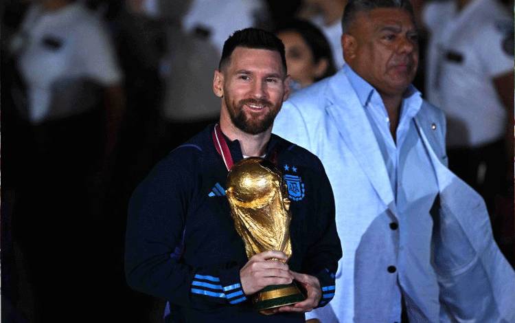 Lionel Messi (tengah) memegang trofi Piala Dunia saat tiba di Ezeiza International Airport, Buenos Aires, Argentia pada 20 Desember 2022 setelah memenangkan Piala Dunia 2022 di Qatar. ANTARA/AFP/LUIS ROBAYO