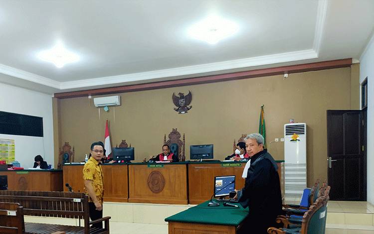 Terdakwa (Batik Kuning) dan Anwar Sanusi (Pakaian Hitam) saat selesai menjalani persidangan di Pengadilan Tipikor Palangka Raya, Kamis, 22 Desember (Foto: Apriando)