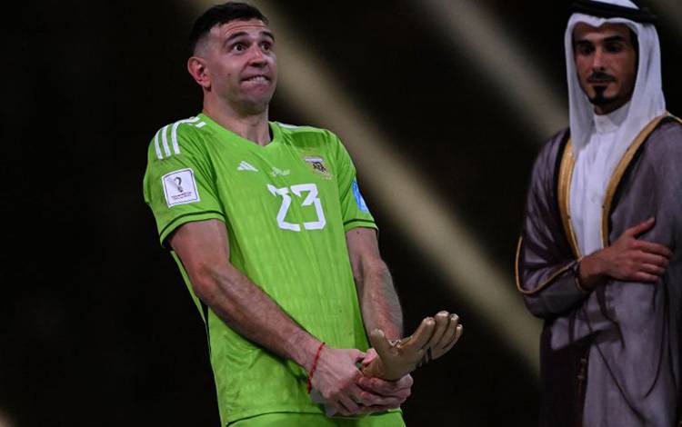 Kiper Argentina Emiliano Martinez berpose dengan hadiahnya setelah dia meraih trofi Sarung Tangan Emas sebagai penjaga gawang terbaik di Piala Dunia 2022 Qatar (AFP/KIRILL KUDRYAVTSEV)