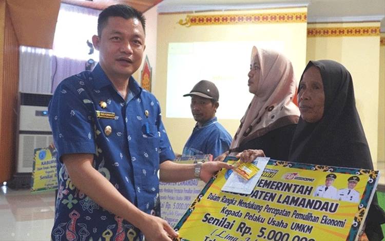 Wakil Bupati Lamandau Riko Porwanto menyerahkan dana hibah belanja produktif kepada salah satu pelaku UMKM di daerah setempat. (FOTO : HENDI NURFALAH)