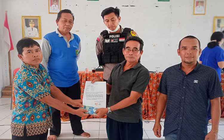 Penyaluran bantuan biaya pembukaan lahan sawit masyarakat di Balai Pertemuan Mira Pakat Desa Tewah Pupuh, Kamis, 29 Desember 2022. (FOTO: BOLE MALO)