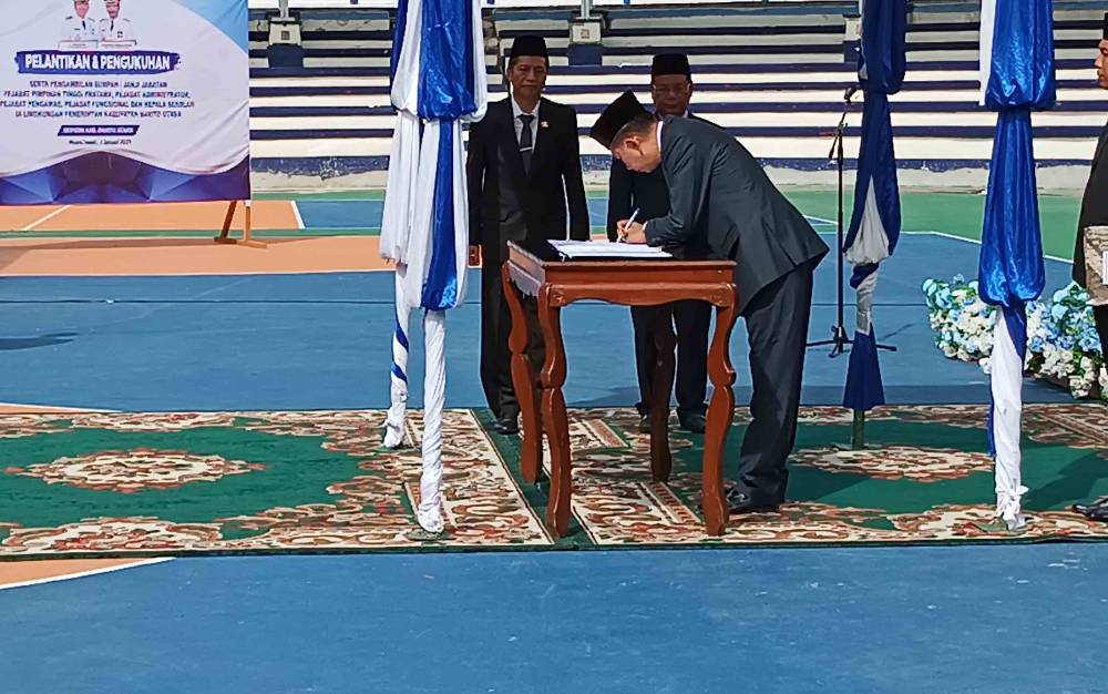 BUpati Barito Utara, Nadalsyah menandatangani surat pelantikan pejabat di lingkup Pemkab Barito Utara, Selasa 2 Januari 2023 di arena terbuka Tiara Batara Muara Teweh.(foto: Dhani)