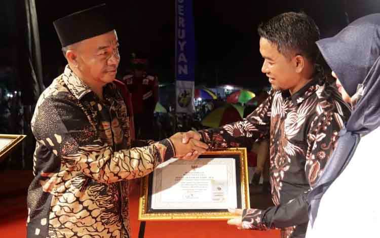 Bupati Seruyan menyerahkan piagam penghargaan kepada Kepala DPMPTSP Seruyan, Agung Setiawan (Foto : PROKOM SERUYAN)