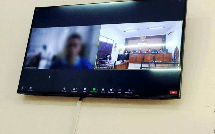 Terdakwa (Kiri) saat menjalani sidang virtual di Pengadilan Negeri Palangka Raya, Rabu, 4 Januari 2023 (Foto: Apriando)