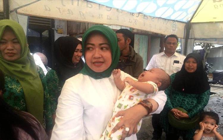 Rima Hartati kader PPP yang juga Caleg DPRD Provinsi No urut 1 itu, menggendong seorang bayi yang orangtuanya menjadi korban kebakaran. ANTARAArumanto