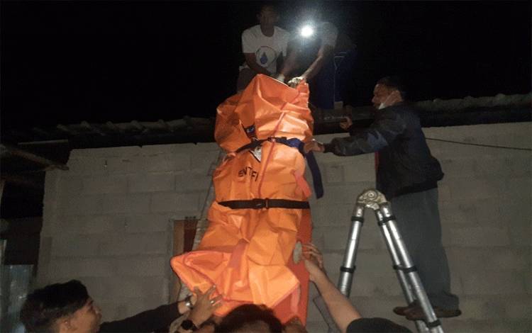 Evakuasi Korban Oleh Emergency Respon Palangkq Raya (ERP) dari atas atap, dimana korban terseteum dan meninggal, Selasa, 10 Januari 2023. (FOTO : AGUS FATARONI M)