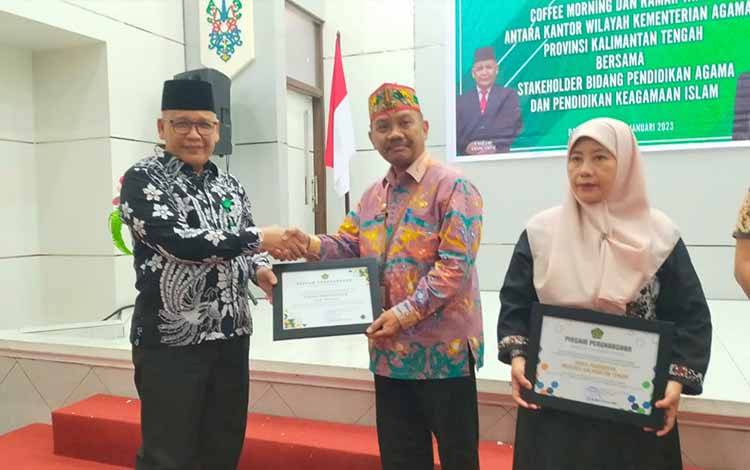 Kepala Dinas Pendidikan Kapuas, Aswan saat menerima penghargaan dari Kepala Kanwil Kemenag Kalteng Noor Fahmi, Jumat, 13 Januari 2023. (FOTO: IST)