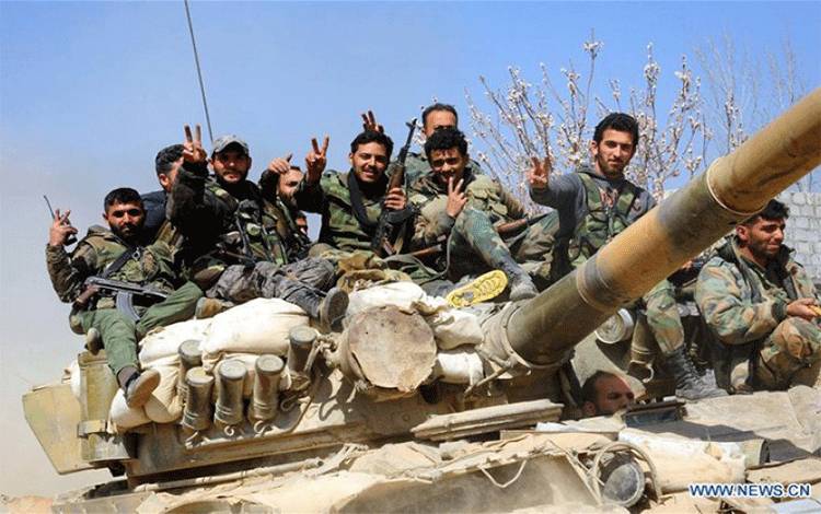 Arsip - Tentara Suriah merayakan kemenangan di atas tank mereka di kota Aftaris wilayah Ghouta Timur Damaskus yang direbut pada Minggu (12/03/2018). (Xinhua/Ammar Safarjalani)