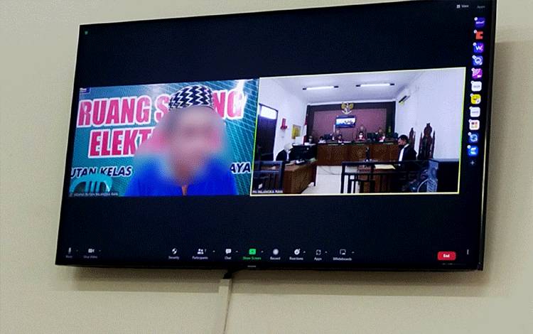 Terdakwa (Kiri) saat menjalani sidang virtual di Pengadilan Negeri Palangka Raya, Selasa, 17 Januari 2023.