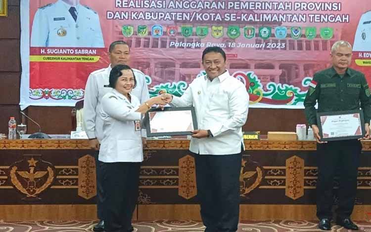 Asisten Administrasi Umum Setda Lamandau, Friaraiyatini, menerima sertifikat penghargaan dari Wagub Kalteng, Edy Pratowo. (FOTO: HENDI NURFALAH)