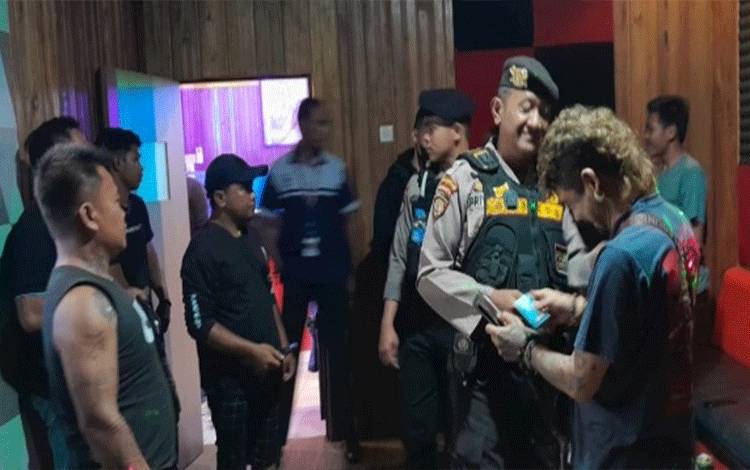Personel Ditsapta Polda Kalteng saat mengecek identitas pengunjung di salah satu karaoke di Jalan Yosudarso Kota Palangka Raya.(FOTO : AGUS FATARONI M)
