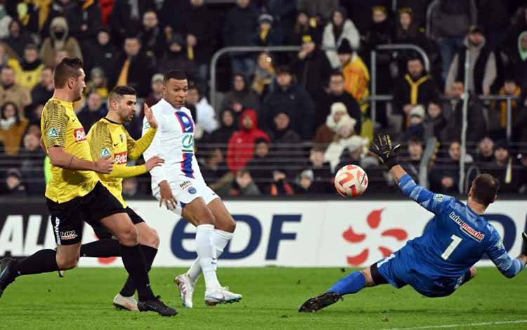 Penyerang PSG Kylian Mbappe (kaus putih) mencetak gol ke gawang Pays de Cassel pada pertandingan 32 besar Piala Prancis 2023 yang dimainkan di Stade Bollaert-Delelis, Lens, Selasa (24/1/2023) WIB. (ANTARA/AFP/Francois LO PRESTI)