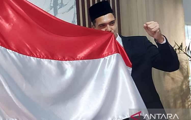 Shayne Pattynama mencium bendera Indonesia usai melaksanakan sumpah janji setia WNI di Kantor Wilayah Kementerian Hukum dan Ham (Kanwil Kemenkumham) DKI Jakarta, Selasa (24/1/2023). (ANTARA/Aditya Ramadhan)