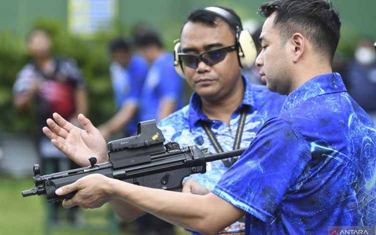 Wakil Komandan Paspampres Marsma TNI Wahyu Hidayat Sudjatmiko (kiri) memberi arahan pada Raffi Ahmad saat akan mengikuti Lomba Menembak Piala Danpaspampres 2022 di Lapangan Tembak Senayan, Jakarta, Minggu (13/3/2022). (ANTARA FOTO/M Risyal Hidayat/foc)
