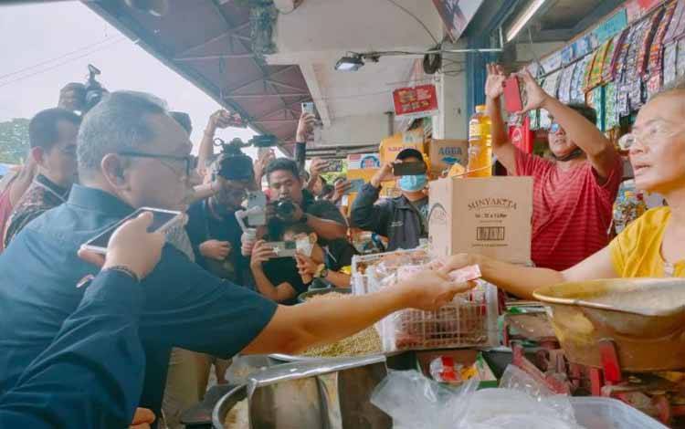 Menteri Perdagangan Zulkifli Hasan saat berbincang dan membeli beras Bulog dari salah satu pedagang di Pasar Kreneng-Denpasar, Sabtu (4/2/2023). ANTARA/Ni Luh Rhismawati.