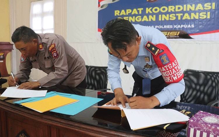 Kasat Binmas Polres Kapuas, AKP Jimin dan Kepala Rutan Kuala Kapuas, Toni Aji Priyanto, menandatangani MoU, Senin, 6 Februari 2023. (FOTO: IST)