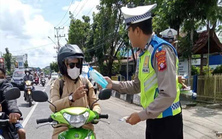 Personel Satlantas Polres Kapuas saat memberikan reward berupa tumbler ke pengendara tertib lalu lintas. (FOTO: IST)