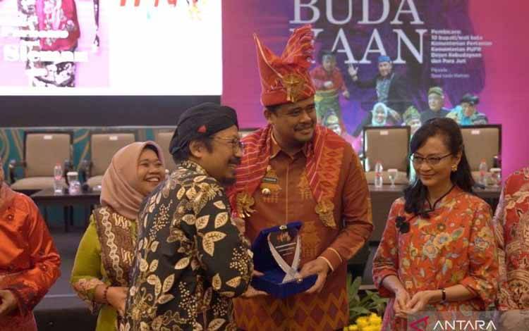 Ketua Pelaksana Anugerah Kebudayaan PWI Yusuf Susilo Hartono menyerahkan plakat kepada Wali Kota Medan Bobby Nasution di Medan, Sumatera Utara, Selasa (7/2/2023). ANTARA/HO-Humas PWI Pusat.