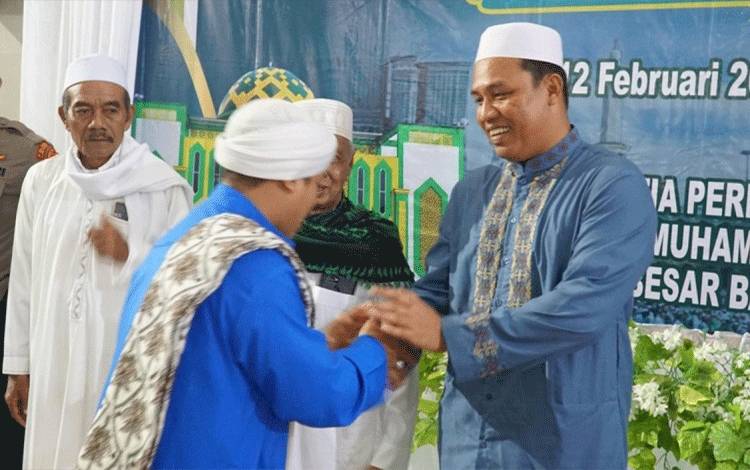 Bupati Lamandau Hendra Lesmana menyalami sejumlah tokoh saat menghadiri acara peringatan Isra Miraj di Masjid Biturrahman Nanga Bulik. (FOTO : HENDI NURFALAH)