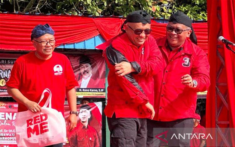 Sekretaris Jenderal DPP PDI Perjuangan (PDIP) Hasto Kristiyanto (kanan) menyematkan jaket partai ke Menteri Koperasi dan UMKM Teten Masduki (tengah) di di alun-alun Rangkasbitung, Lebak, Banten, Minggu (19/2/2023). (ANTARA/Fauzi Lamboka)