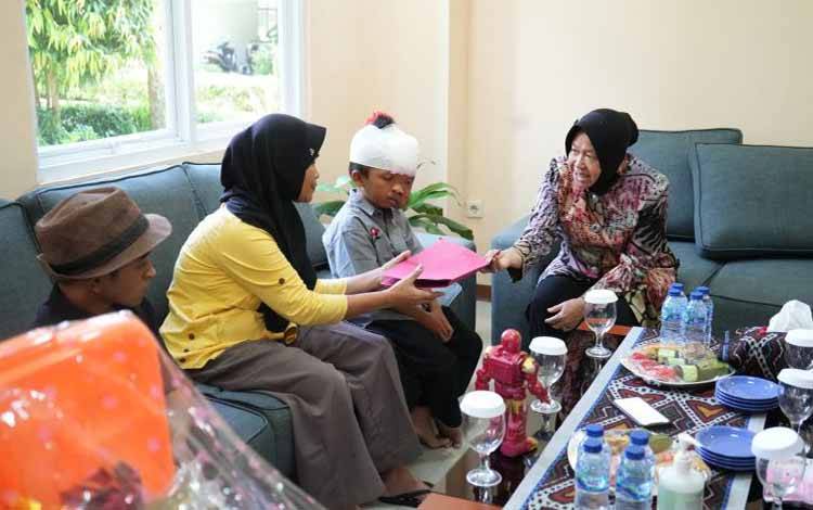 Menteri Sosial Tri Rismaharini memberikan bantuan ATENSI untuk pengobatan bocah penderita tumor wajah di Sentra Handayani, Jakarta, Senin (20/2/2023). (Antara/HO-Kemensos)