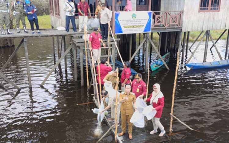 Anggota DPD RI Agustin Teras Narang bersama Bupati Katingan Sakariyas menabur benih ikan papuyu di Danau Bulat Kamipang, Selasa, 21 Februari 2023. (FOTO: ISTIMEWA)