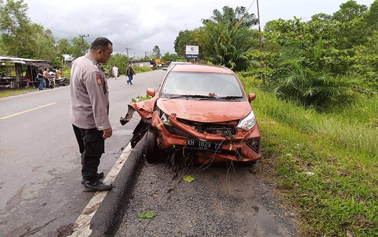 Kepala SPKT Polsek Sebangau Aiptu Cecep saat mengecek kondisi mobil korban laka, Minggu 5 Maret 2023. (FOTO : POLSEK SEBANGAU)