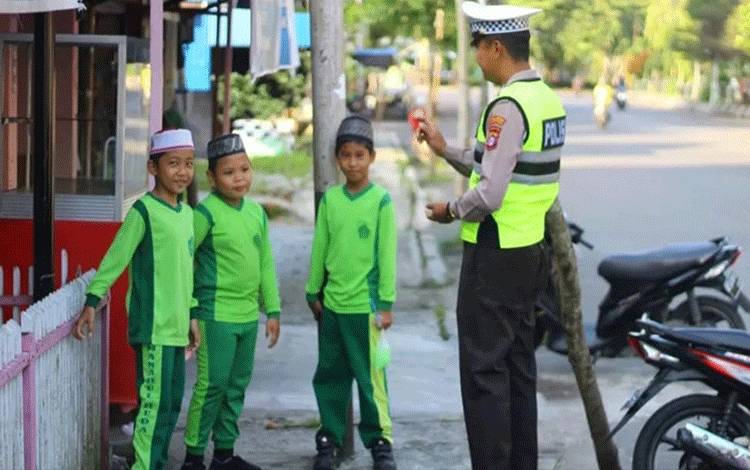 Personel Satlantas Polres Kapuas saat edukasi pelajar tumbuhkan disiplin dalam berlalu lintas. (FOTO: IST)