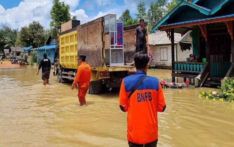 Sejumlah petugas BPBD Kabupaten Lamandau tengah melakukan evakuasi warga terdampak banjir di Kecamatan Batang Kawa. (FOTO : HENDI NURFALAH)