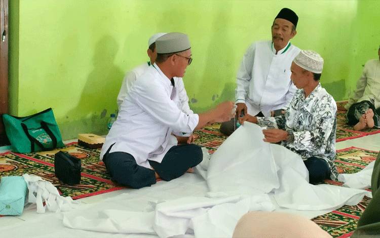 Pemateri dari MUI Kabupaten Lamandau tengah mempraktikan cara pemulasaran jenazah menurut syariat agama Islam. (FOTO : HENDI NURFALAH)