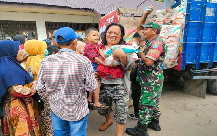 Ibu Yurince saat mengambil beras operas pasar di Kelurahan Panarung (FOTO : PATHUR)