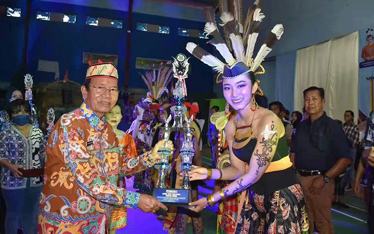 Wabup Kapuas, HM Nafiah Ibnor, MM saat menyerahkan Piala Penghargaan kepada salah satu pemenang terbaik 1 pada acara Festival Seni Budaya TMPT Kabupaten Kapuas Tahun 2023. (FOTO: IST)