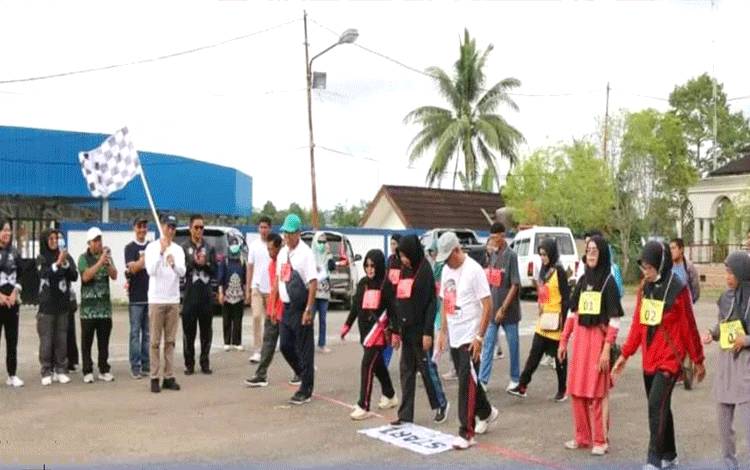 Sekda Barito Utara, Drs Muhlis saat mengibarkan bendera jalan sehat bagi para calon jamaah haji dalam rangkaian pemeriksaan kebugaran di halaman kantor bupati, Sabtu 18 Maret 2023.(foto: Dhani)