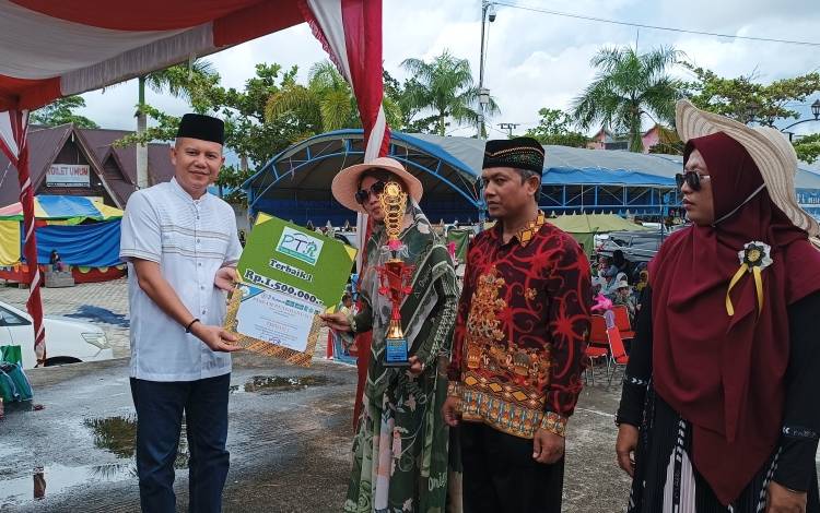 Bupati Gunung Mas Jaya S Monong saat menyerahkan hadiah kepada juara terbaik I pawai tarhib ramadan, Sabtu, 18 Maret 2023. (FOTO: RISKA YULYANA)