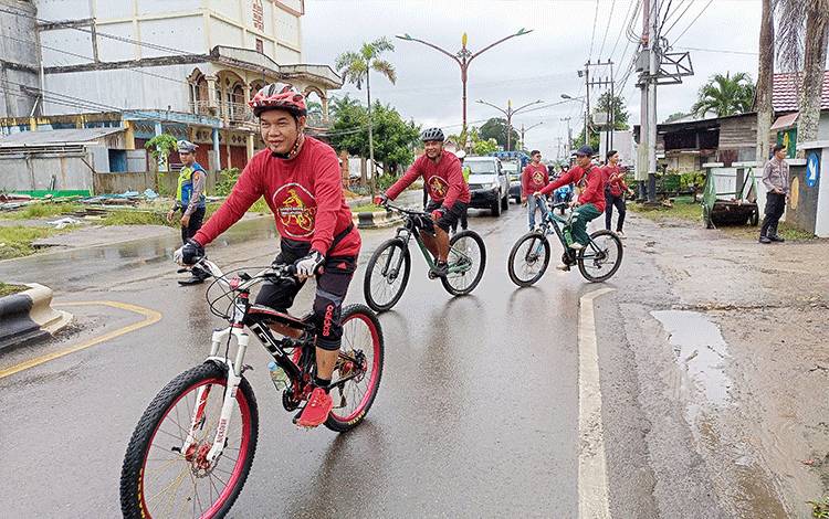 Bupati Barito Timur Ampera AY Mebas dan Kapolres AKBP Viddy Dasmasela bersepeda di tengah cuaca gerimis Kota Tamiang Layang pada Jumat, 17 Maret 2023. (FOTO: BOLE MALO)