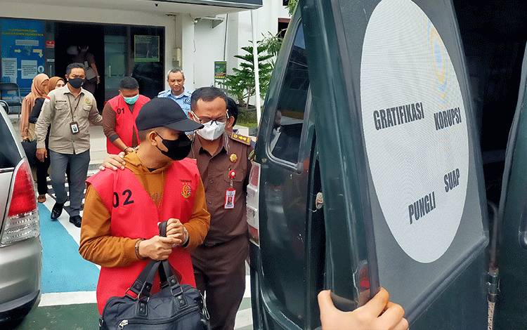 Dua tersangka kasus korupsi dana KUR BRI Unit Yos Sudarso (rompi oranye) digiring petugas Kejaksaan Negeri Palangka Raya, Selasa 7 Maret 2023 ( Foto: Apriando)