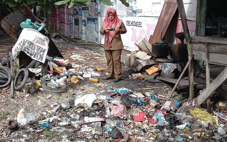 Kadis DLH Kobar Fitriyana saat memonitoring tumpukan sampah di Jalan A Yani, Kelurahan Baru. (FOTO : Fitriyana)