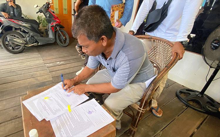 Warga Puntun menandatangani persetujuan relokasi dan bongkar sendiri bangunan lama. (FOTO: HENDRI)