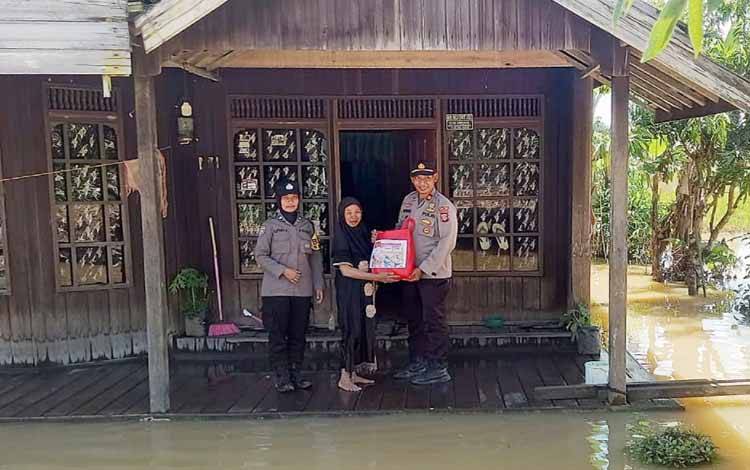 Polsek Dusun Tengah memberikan bantuan bahan kebutuhan pokok kepada warga terdampak banjir di Desa Ampah Dua Kabupaten Barito Timur, Rabu, 29 Maret 2023. (FOTO: HUMAS POLSEK DUSTENG)