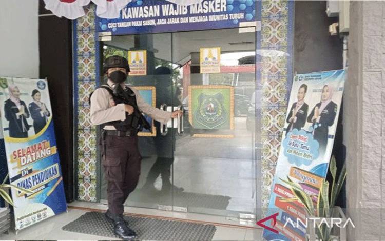 Aparat Kepolisian menjaga pintu masuk kantor Dinas Pendidikan Kabupaten Kapuas saat mengamankan kegiatan penggeledahan yang dilakukan penyidik KPK, Kamis (30/3/2023). ANTARA/All Ikhwan