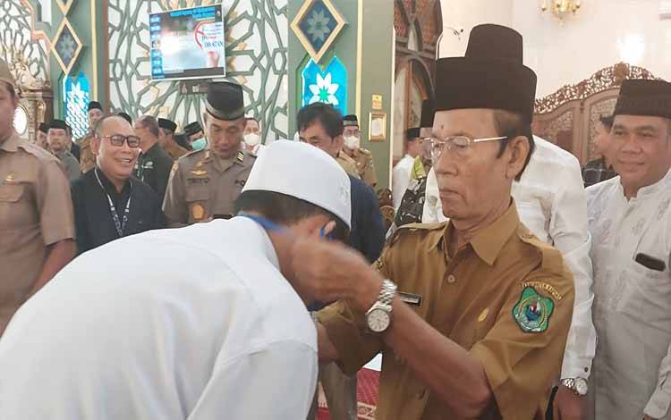Wakil Bupati Kapuas, Nafiah Ibnor saat mengalungkan tanda peserta tandai mulainya Pesantren Ramadan di Masjid Agung Al-Mukarram, Selasa, 4 April 2023. (FOTO: DODI)