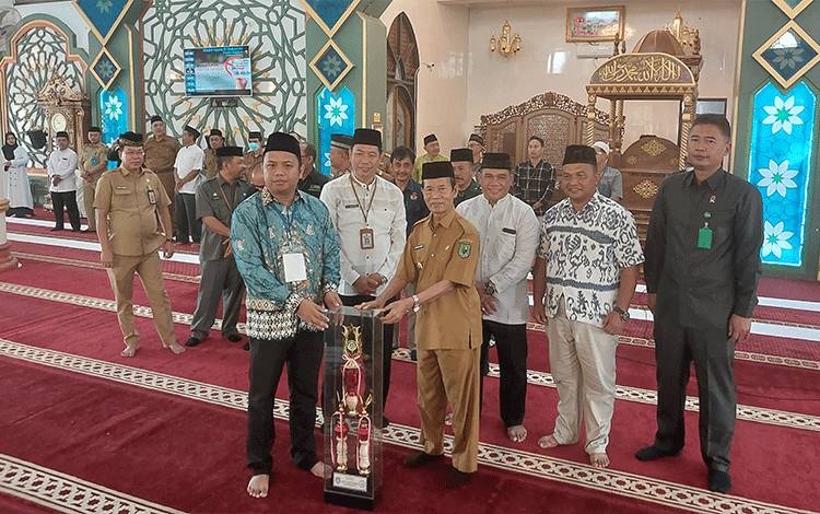 Wakil Bupati Kapuas, HM Nafiah Ibnor saat menyerahkan piala bergilir kepada panitia pelaksana Pesantren Ramadan 1444 H di Masjid Agung Al-Mukarram, Selasa, 4 April 2023. (FOTO: DODI)