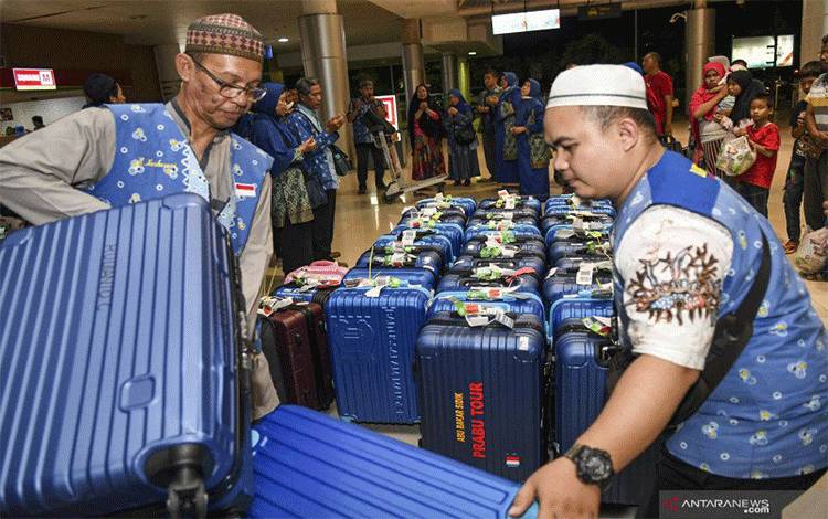 Ilustrasi - Petugas menurunkan koper calon jamaah umrah yang batal berangkat ke Jeddah lewat Singapura saat tiba di Bandara International Sultan Mahmud Badaruddin (SMB) II Palembang, Sumatera Selatan, Jumat (28/2/2020). ANTARA FOTO/Nova Wahyudi/nz