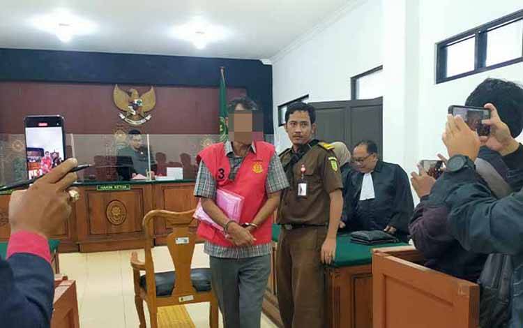 Terdakwa saat digiring petugas usai menjalani sidang dakwaan di Pengadilan Negeri Palangka Raya, Rabu, 12 April 2023.