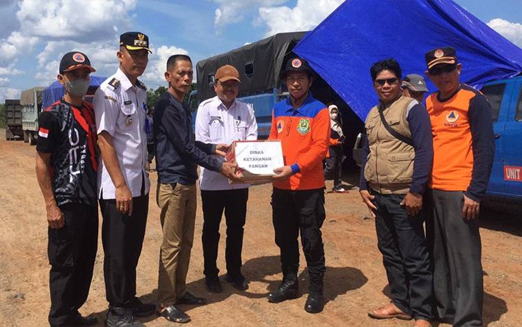 Kepala Pelaksana BPBD Kapuas, Panahatan Sinaga secara simbolis menyerahkan bantuan untuk warga terdampak banjir di Kecamatan Mantangai. (FOTO: BPBD KAPUAS)