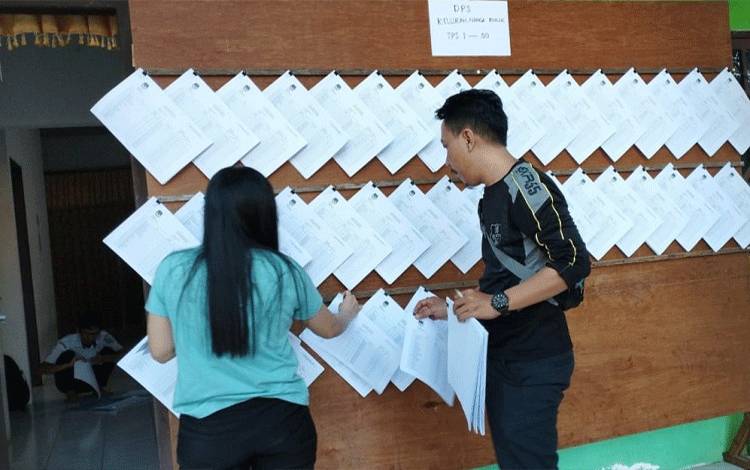 Anggota PPS Nanga Bulik, Kecamatan Bulik tengah menempel Daftar Pemilih Sementara Pemilu 2024 di Sekretariat PPS setempat. (FOTO : HENDI NURFALAH)