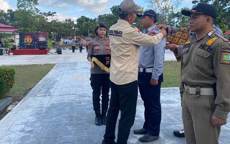 Bupati Sukamara, Windu Subagio menyematkan pita kepada personil dalam Apel Gelar Pasukan Operasi Ketupat Telabang 2023, Senin, 17 April 2023. (FOTO: NORHASANAH)
