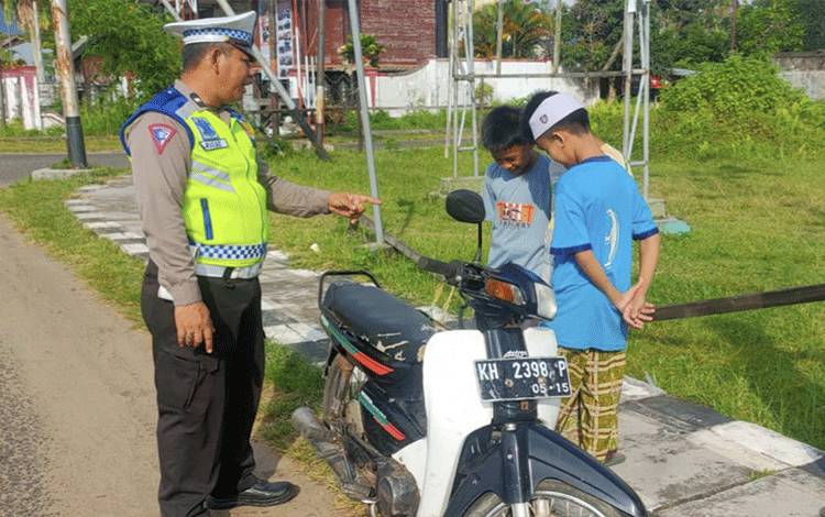 Personel Satlantas Polres Seruyan saat memberikan teguran kepada anak anak dibawah umur yang kedapatan gunakan kendaraan. ( Foto : Ist)